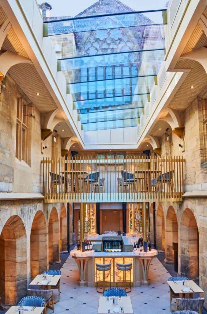 Hallway of historical hotel with glass roof created y multipart rooflight